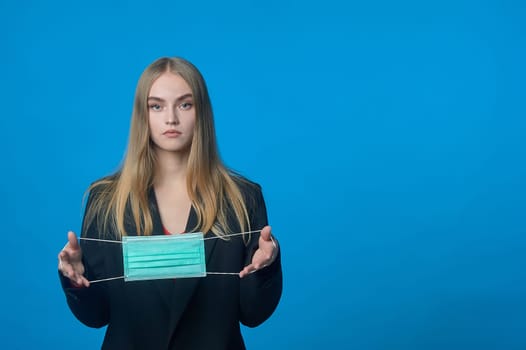 Girl with a medical mask in her hands. High quality photo