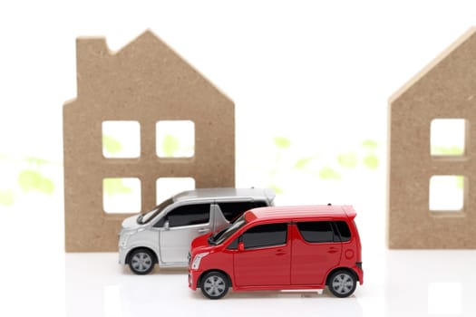 Wooden toy house and toy car isolated on white background