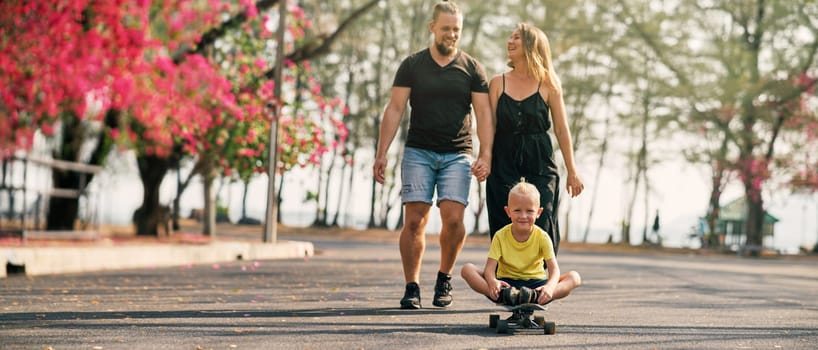 Happy family of father, mother and son walking in blossoming spring park. End of quarantine. Banner
