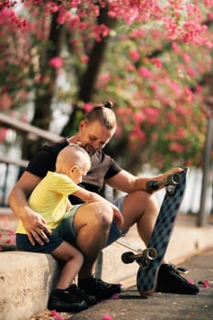 Father is hugging his little son in skate park. Springtime. Real family. Spending quality time together