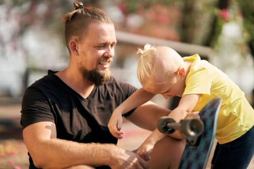 Father is spending quality time with with his little son in skate park Springtime. Family time together