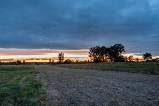 Plowed rural field and evening clouds with sunset, Zarzecze, Lubelskie, Poland
