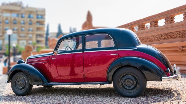 Cairo, Egypt- July 29 2020: 1953 Black and red Mercedes antique car, displayed in front of Baron Empain Palace