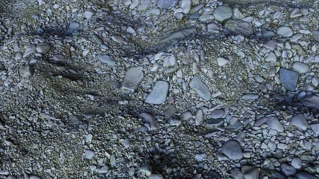 Realistic beach terrain with blurred sea of mounds of stones 3D render with convex curvatures and irregularities. Piles of small and large pebbles lying in random order and crumbling.