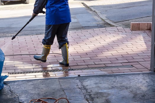 Cleaning concrete block floor by high pressure water jet.