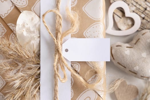 Valentines present with horizontal gift tag, heart and pampas grass close up. Spring scene with blank label. Rustic, cottage chic or bohemian mockup, copy space