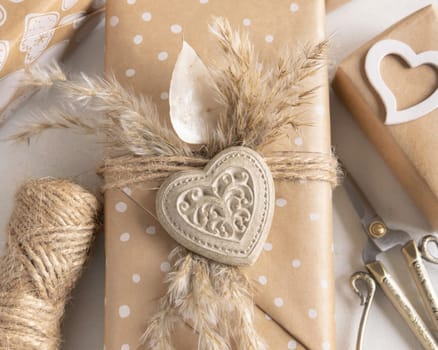 Valentines Day present wrapped in kraft paper and decorated with heart and pampass grass top view. Spring rustic, cottage chic or bohemian concept