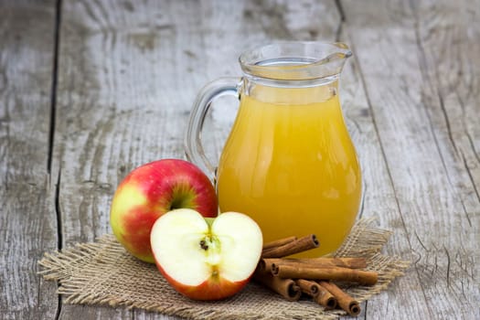 Apple juice and apples on wooden background