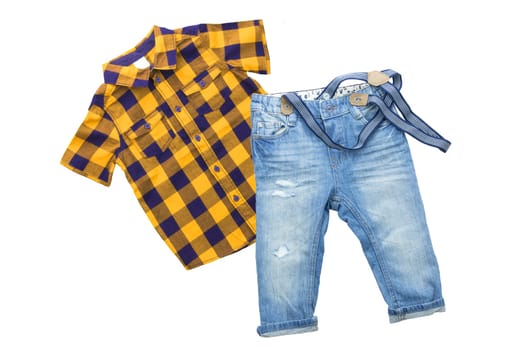 Fashionable blue jeans with braces or suspenders for child boy and a yellow blue checkered shirt with short sleeves isolated on a white background. Kids summer clothes.