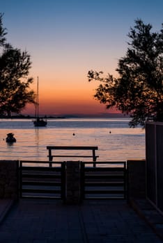 View from the yard to the sea, sailing boat and a beautiful sunset.