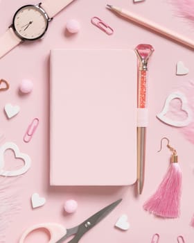Hardcover notebook, Pink school accessories and hearts on light pink, Top view, textbook mockup. Girly workplace with notebook, scissors, pencil, pen, paperclips, earrings and watch. Back to school