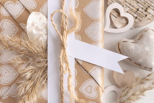 Valentines present with horizontal gift tag, heart and pampas grass close up. Spring scene with blank label. Rustic, cottage chic or bohemian mockup, copy space