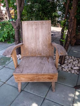 The old hardwood in garden chair with tree.
