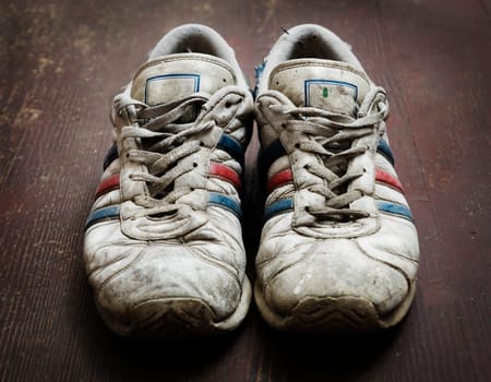 Dirty old shoes on wooden floor