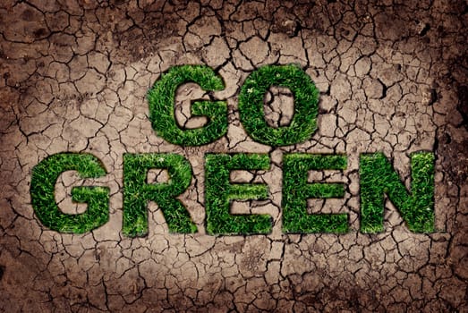 Eco concept. Grass growing from dry soil in Go Green shape.