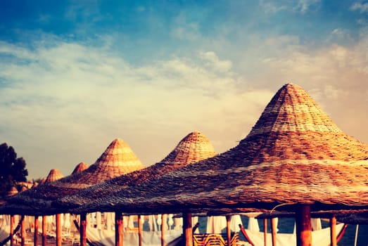 Thatched parasols on the beach at sunset