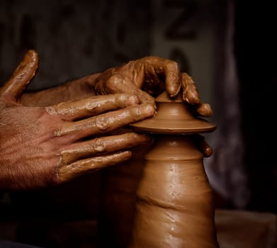 Potter shaping clay on the pottery wheel