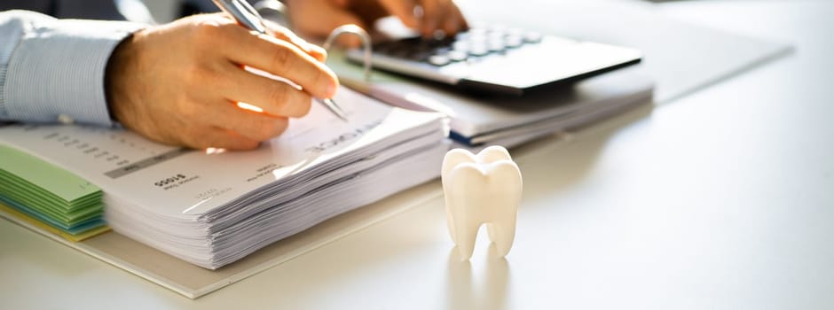 Dentist Bill And Tax Paperwork At Desk