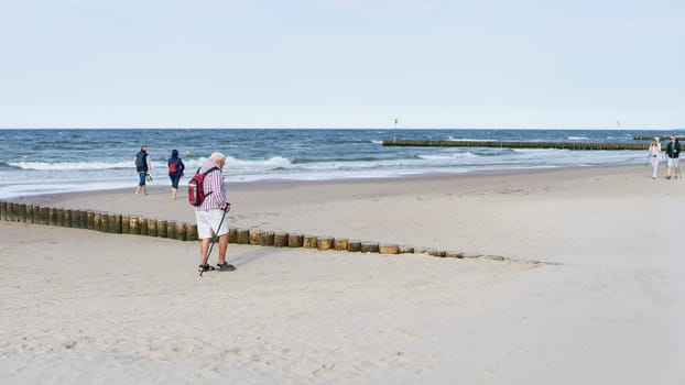 Strollers on the beach of Kolobrzeg on the Polish coast of the Baltic Sea