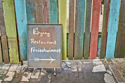 Sign at the entrance of the popular restaurant Freischwimmer at the Flutgraben in Berlin. Translation on the sign: Entrance Restaurant Freischwimmer