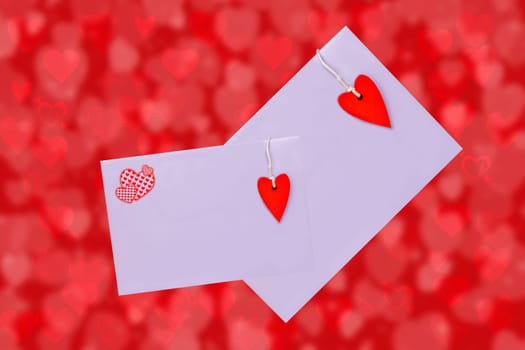 Happy Valentine or Mothers Day card template. 3D illustration of two envelopes with red hearts made of wood over abstract red background with hearts. Space for text design.
