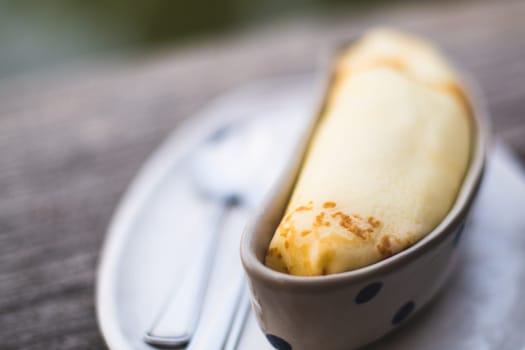 Banana crepe sweet dessert object still life. The crepe put in the ceramic container bowl banana shape form design.