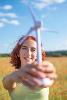 girl with wind turbine in poppy field
