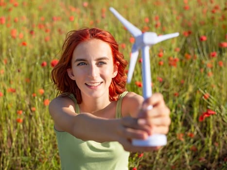 girl with wind turbine in poppy field