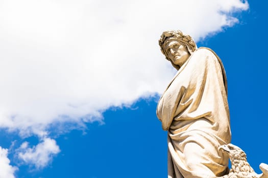 Dante Alighieri statue in Florence, Tuscany region, Italy, with an amazing blue sky background.