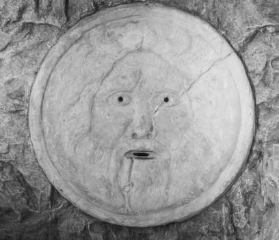Mouth of truth sightseeing in Rome, Italy. Historical sculpture made of marble with antique face full of mystery and legend.