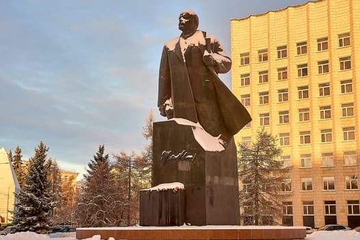 monument of Vladimir Lenin against the background of the city dusted with snow in winter. High quality photo
