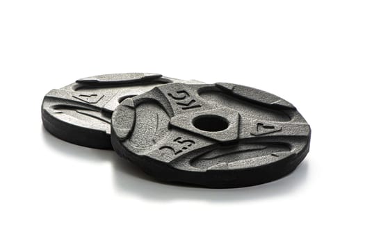 Two black metal pancakes of 2.5 kg each lie on a white isolated background. High quality photo