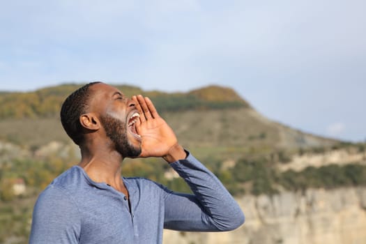 Side view portrait of a man with black skin screaming in nature