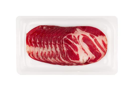 top view of slices of smoked pork loin ham with red color and fat in transparent plastic packaging isolated on white background