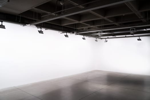 front view of exhibition industrial style interior with lights and empty white walls