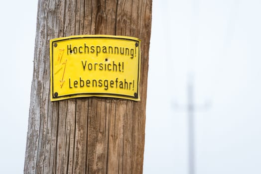 Electric pole warning sign in yellow