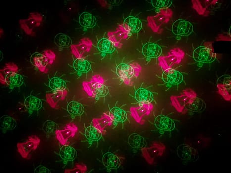 A beautiful shot of laser lights with star and firework shapes on the wall.