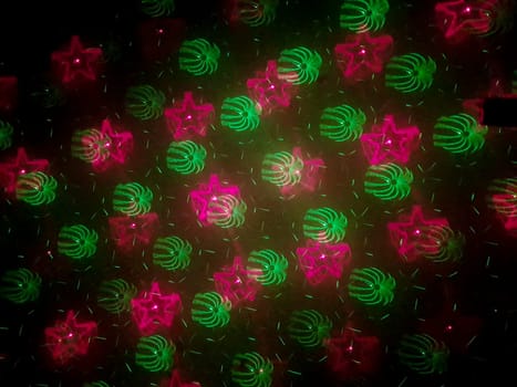 A beautiful shot of laser lights with star and firework shapes on the wall.