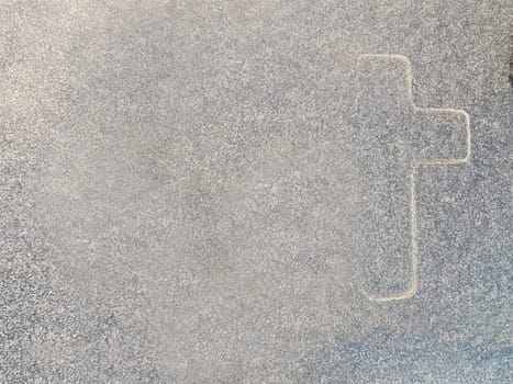 The outline of a cross on marble. A symbol of Christianity on gray marble. The main symbol of Christianity.