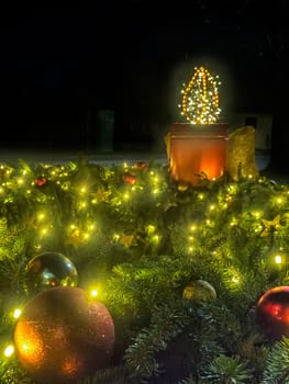 A large Advent candle made from a bucket. Christmas decoration on black background. Christmas atmosphere. An atmosphere of love, hope, peace, joy.