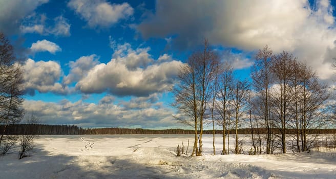 White clouds over a frozen lake. Winter day. Leningrad region.