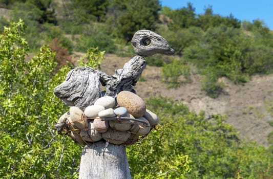 A sculpture made of stones and wood in the form of a bird in a nest