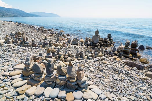 Pyramids of sea stones on the seashore .Entrance to the sea.