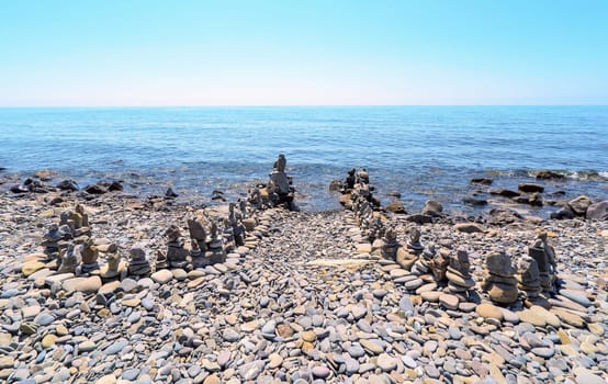 Pyramids of sea stones on the seashore .Entrance to the sea.