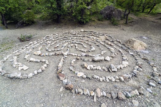 A maze lined with stones, in a clearing in a mountain forest. Crimea