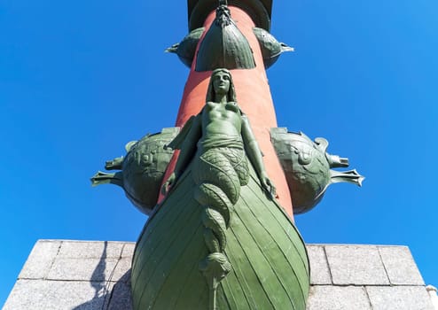 The statue at the foot of the Rostral Column. The arrow of Vasilievsky Island. Saint-Petersburg. Russia