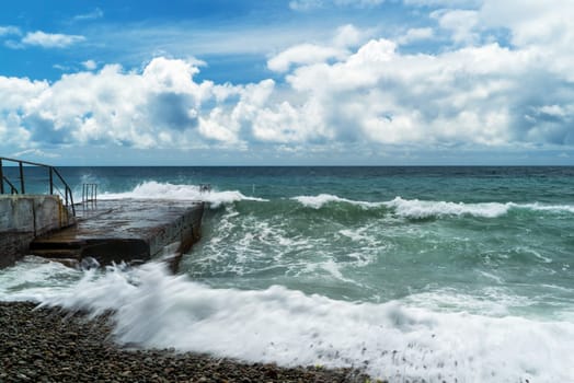The sea is stormy. Large waves break on the breakwater .Crimea