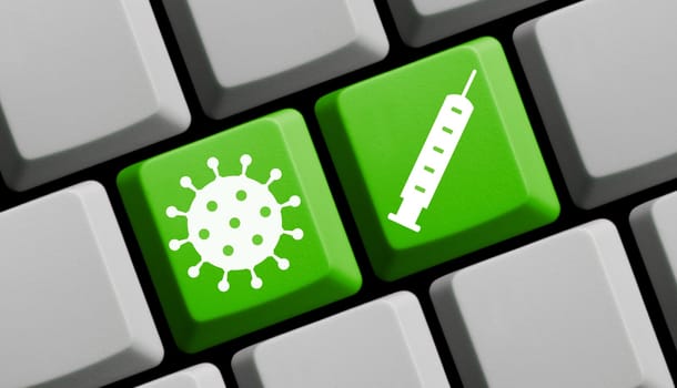 Covid-19 vaccination - Green computer keyboard with coronavirus symbol and vaccine