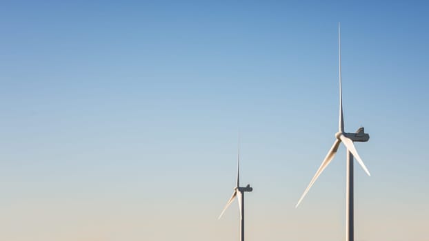 Wind turbines on a beautiful blue sky in a mountain wind farm in Sardinia. Renewable energy concept, green energy generation. Energy industry.