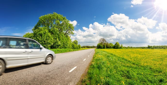 Panoramic view of the asphalt road with car on it. Beautiful highway in spring natural park in countryside.